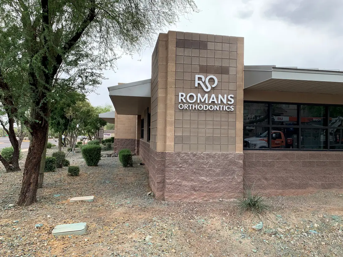 The exterior of the building on W. Anthem Way, with the Romans Orthodontics monument sign and parking outside