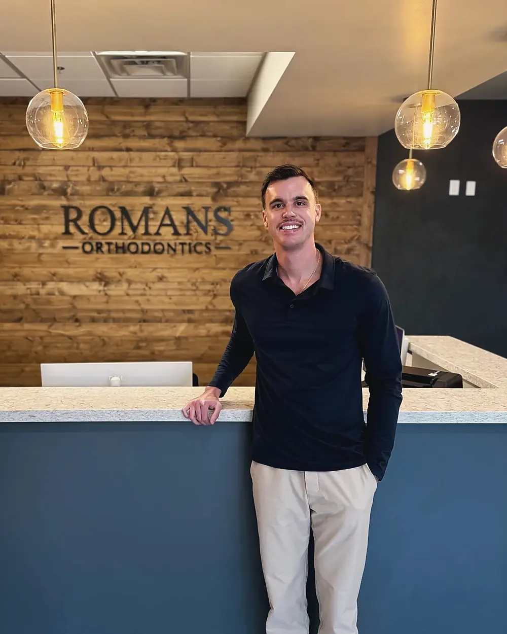 Dr. Nicholas Romans at the reception desk of Romans Orthodontics in Anthem, Arizona