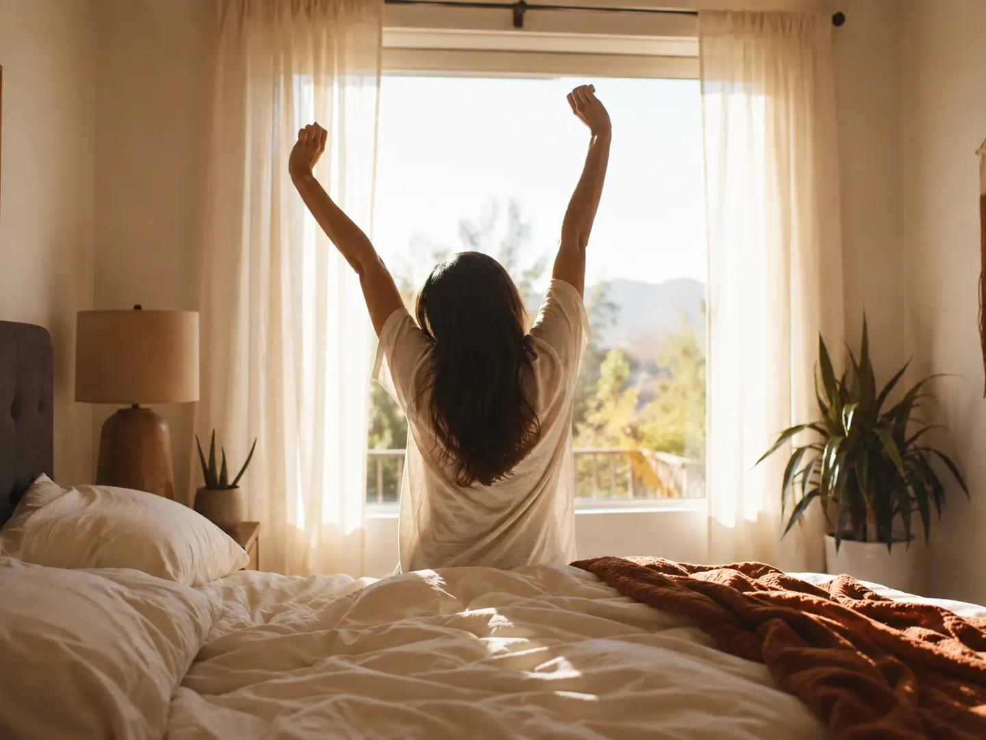 A person stretching in front of a bright bedroom window in the morning